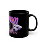 a black coffee mug with a picture of a dog on it